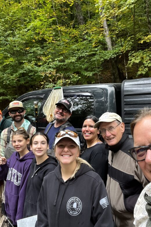 Volunteers conducting trout sampling stand together for photo